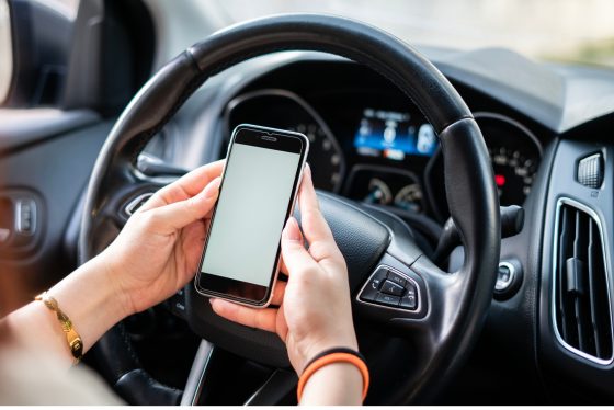 Conductor imprudente haciendo uso de su teléfono celular mientras conduce su vehículo.