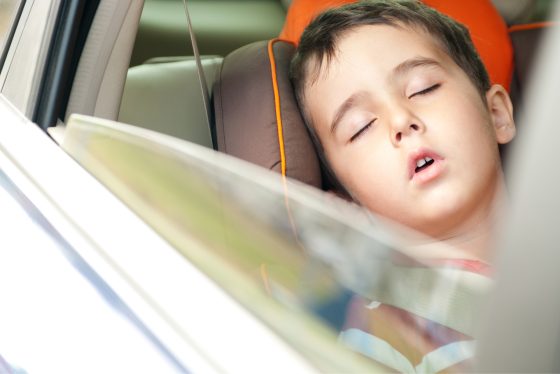 Niño durmiendo dentro de un vehículo.