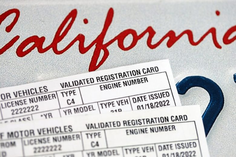 Tarjetas de registración del DMV de California sobre una superficie, representando la registración de mi vehículo y documentos oficiales del auto.