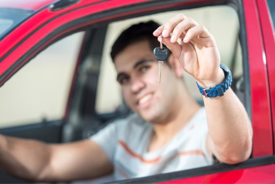 Hombre sonriendo por encontrar seguros de autos para hispanos.