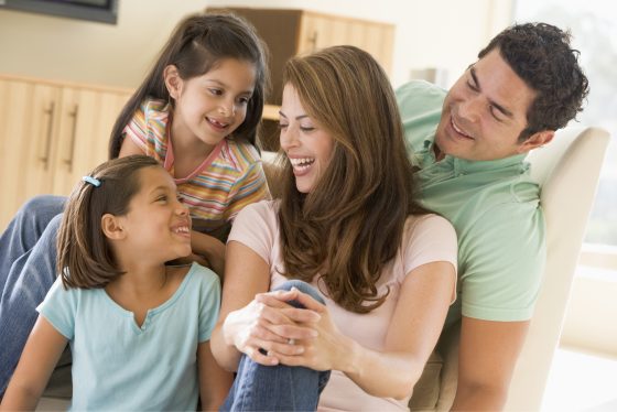 Familia feliz disfrutando de un ambiente bien iluminado dentro del hogar.