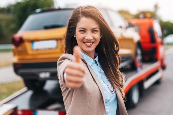 Mujer sonriendo por encontrar aseguradora de carros.