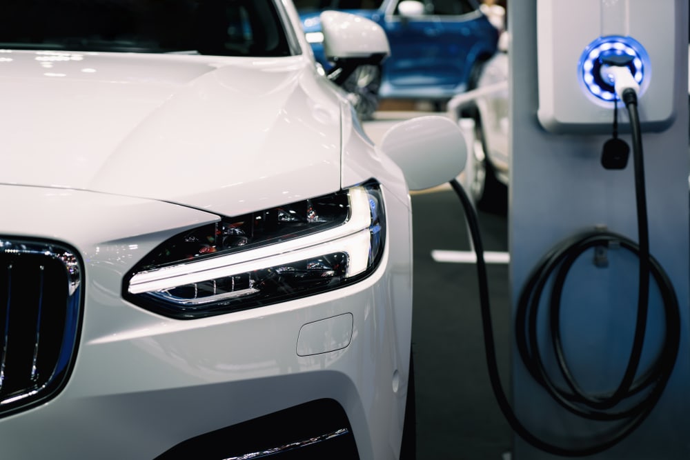 Auto eléctrico blanco parqueado mientras se carga