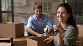Matrimonio desempacando sus pertenencias en su nueva casa con seguro de arrendamiento