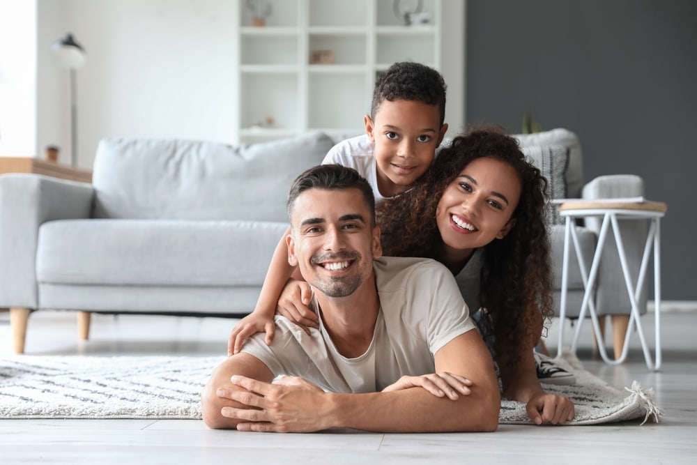 Familia hispana feliz por tener un seguro de vida con beneficios en vida