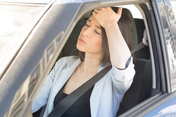 Mujer preocupada con la mano en su cabeza pensando Por qué las aseguradoras de auto en California no me pueden asegurar