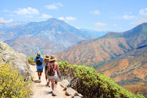 Grupo de tres amigos en una montaña para hacer hiking en Californioa