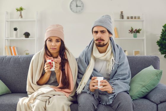 Pareja latina bebiendo té para recuperarse de enfermedades de invierno