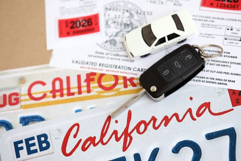Placas, registro y llaves de auto con sticker de carro en California.