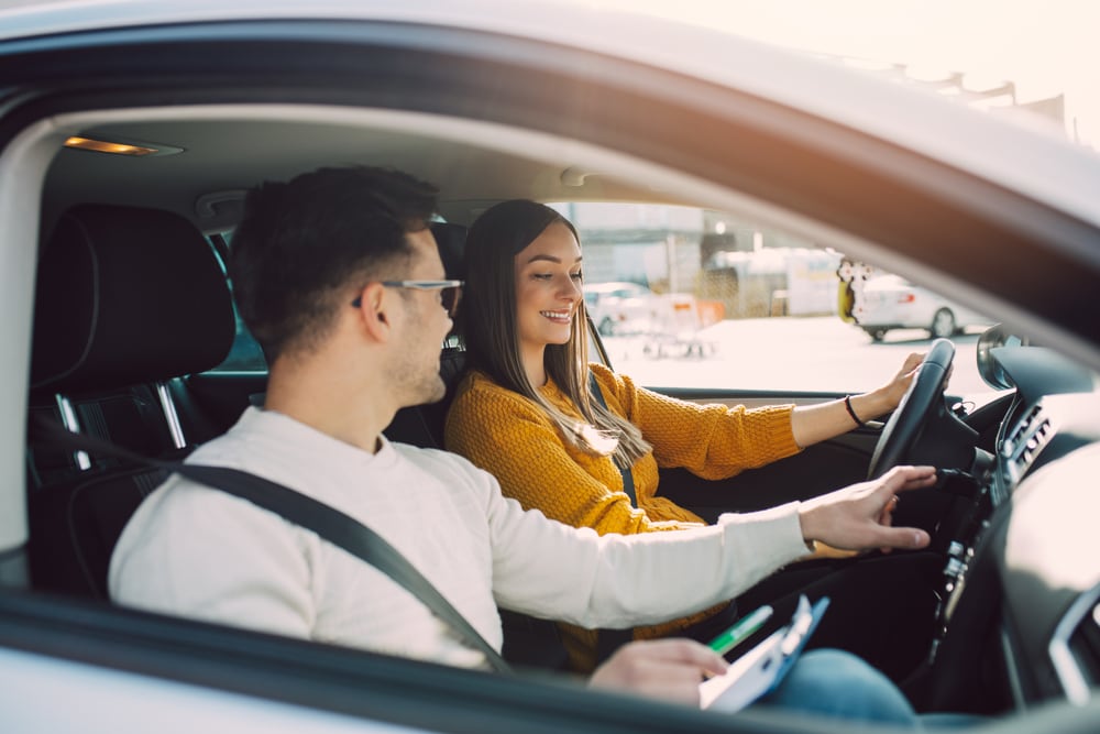 Mujer joven junto a su instructor en examen de manejo DMV en California