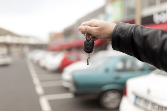 Hombre con llave de auto en mano después de descubrir qué necesito para comprar carros en subasta