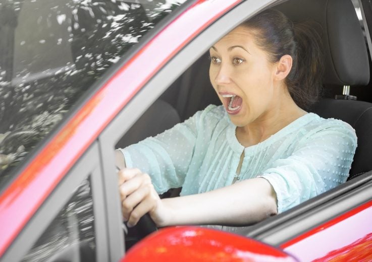 Mujer hispana pensando qué hacer si te quedas sin frenos en un carro automático