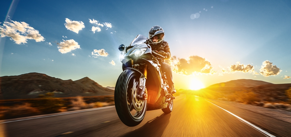 Motociclista circulando en las carreteras de California con tranquilidad al saber cómo asegurar tu moto