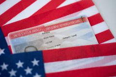 Tarjeta de permiso para trabajar en Estados Unidos sobre bandera de USA