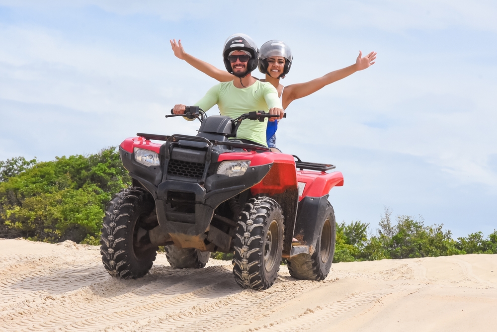 Pareja latina sonriendo por tener un seguro para ATV que los respalde