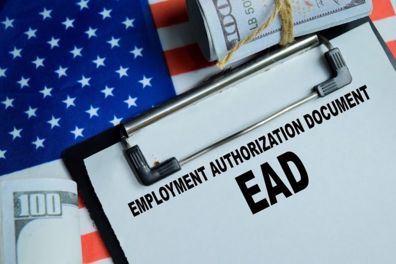 Documento de autorización de empleo (EAD) sobre una bandera de Estados Unidos junto a dinero en efectivo, representando el permiso de trabajo en EE. UU.