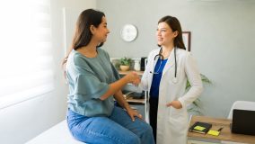 Una doctora teniendo una consulta con una paciente con una enfermedad preexistente en California