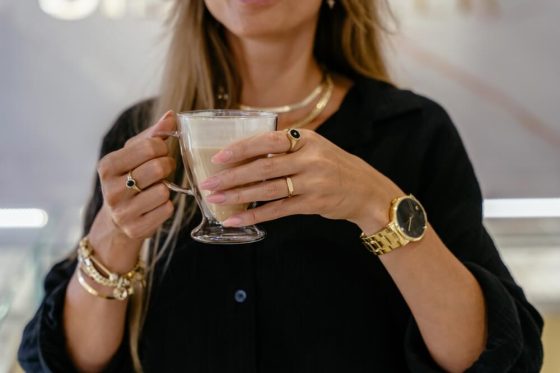 Mujer elegante con pulseras y anillos dorados trabajando en una joyería, ejemplo de personas exitosas en pequeños negocios con seguro para objetos de valor