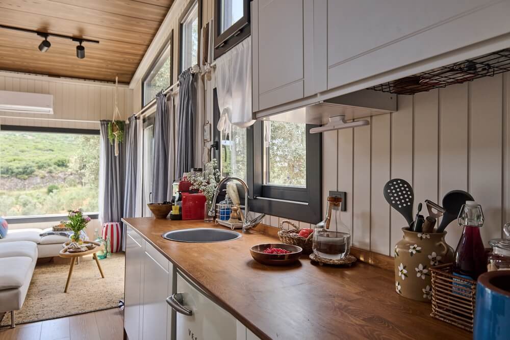 Interior de tiny house con materiales no tradicionales, asociado a seguro de hogar en California
