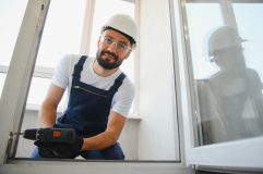 Trabajador repara una ventana en casa, ejemplo de un reclamo pequeño en tu seguro de hogar