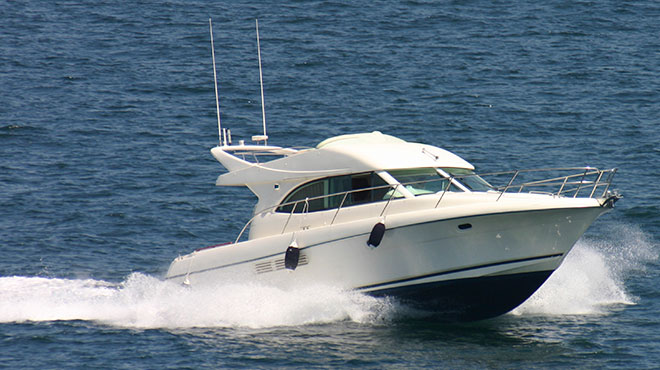 Vista lateral de un bote navegando velozmente en el agua con seguro