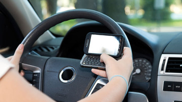 conductor imprudente haciendo uso de su teléfono celular mientras conduce su vehículo