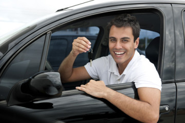 Conductor feliz sosteniendo la llave de su vehículo al obtener su seguro de auto.