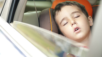 Niño durmiendo dentro de un vehículo