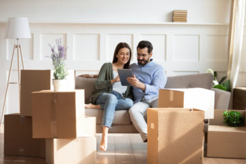 Pareja hispana sentada en sillon viendo una tableta
