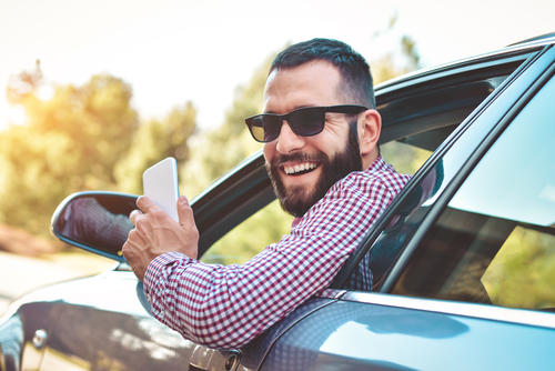 Hombre adulto sonriendo en la ventana de su auto