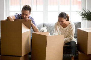 Pareja de hispanos desempacando en una casa de renta