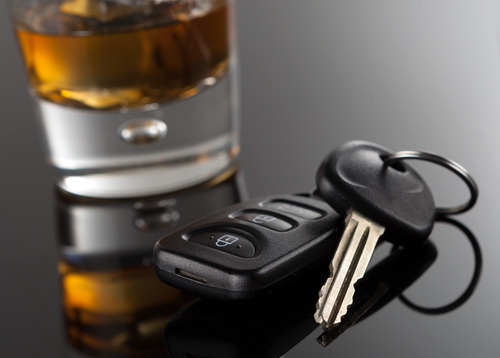 Llaves a un costado una bebida alcoholica