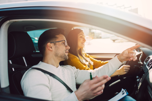 Hombre y mujer conduciendo mientras practican consejos de seguridad vial