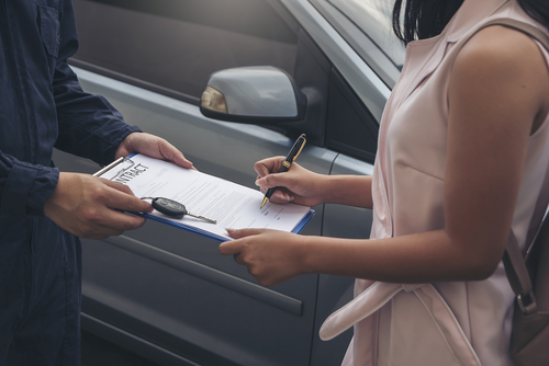 Mujer firmando su contrato de seguros de autos para hispanos