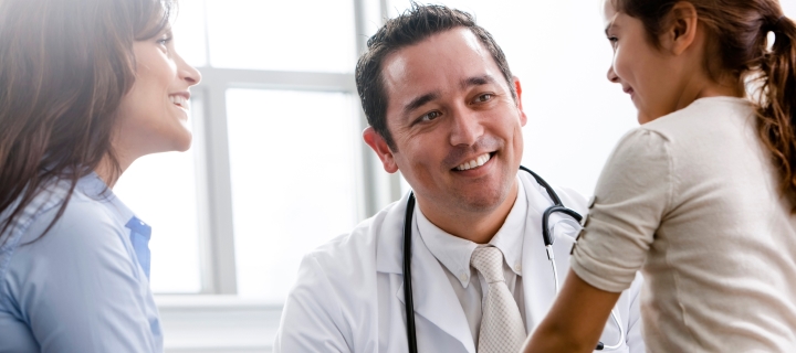 Madre llevando a su hija pequeña al doctor