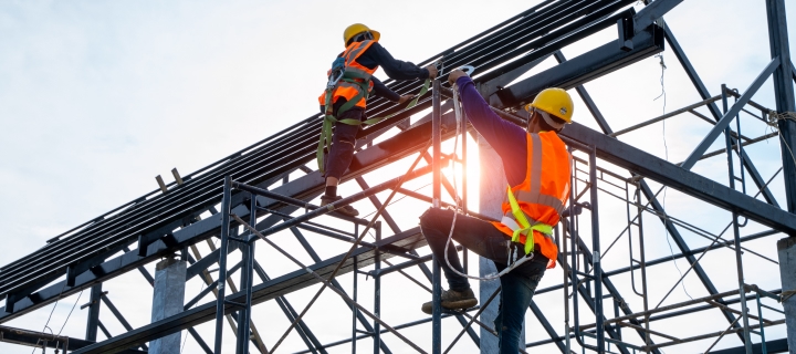Trabajadores de construcción subiendo vigas