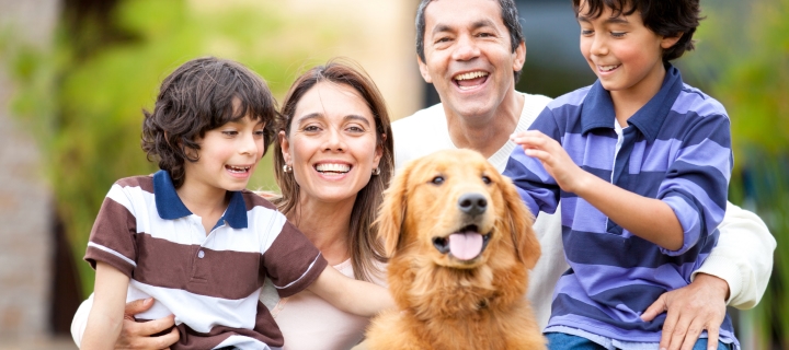 Familia hispana con su perro feliz de tener plan de descuentos de salud de mascotas.