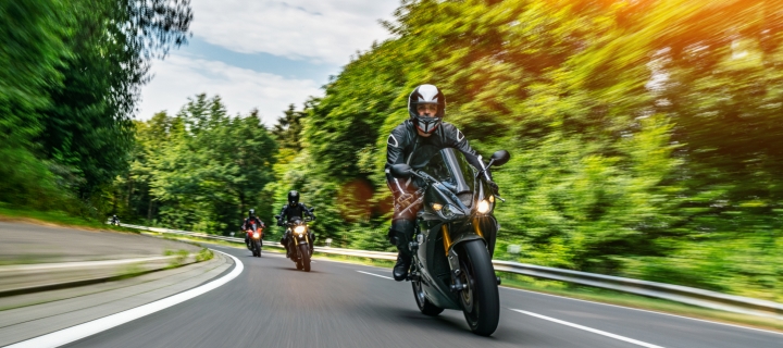 Tres motociclistas disfrutando de sus vehículos en la carretera