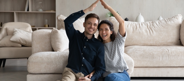 Pareja latina feliz de tener su nuevo hogar protegido con un seguro de inquilinos.